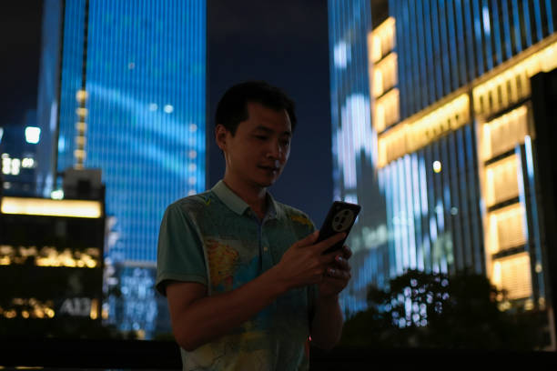 istock A young Asian man using a smartphone on a blue background 2180018895