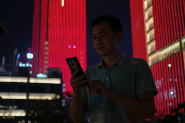 istock A man was walking down the street at night using his cell phone 2180018934