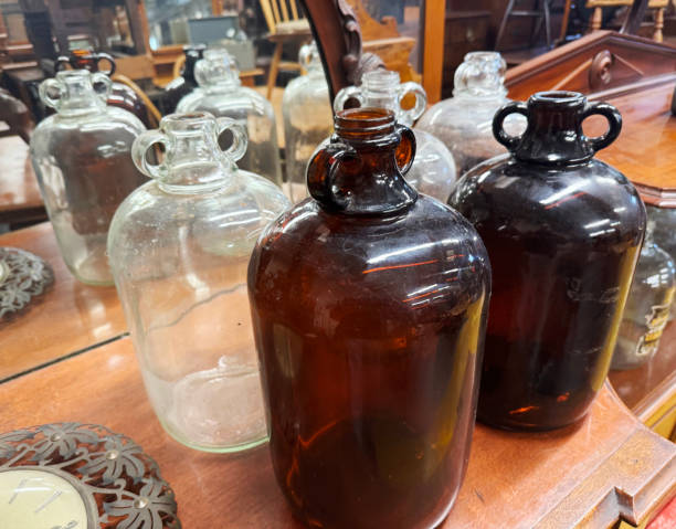 Multicoloured demijohns on a wooden table in a flea market in Norwich