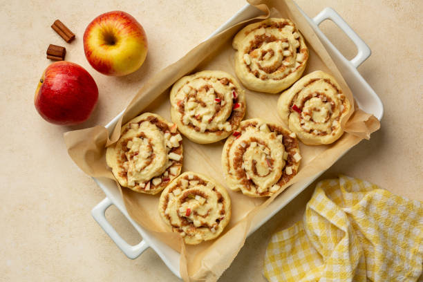 istock Cooking Homemade Rolls Buns with apples and cinnamon. Uncooked, raw daught. Top view, flat lay, beige background. 2180021589