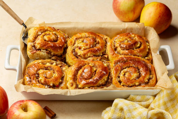 istock Homemade baked Rolls Buns with apples, walnut and cinnamon, glazed. Beige table background. 2180021606