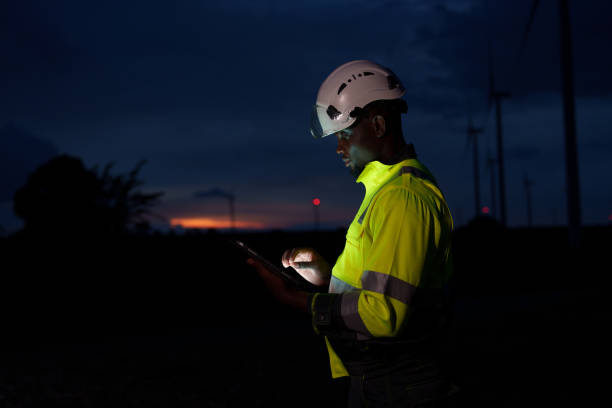 istock Solar engineers work at night using iPads outside power stations and wind turbines to protect inspectors 2180025025