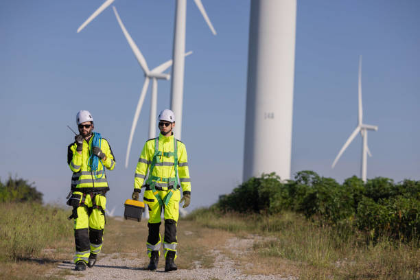 istock Engineers inspect the large wing turbine farm 2180025090
