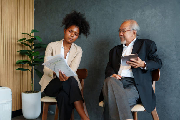 istock Two business colleagues of different ages are discussing project documents in an office. 2180025207