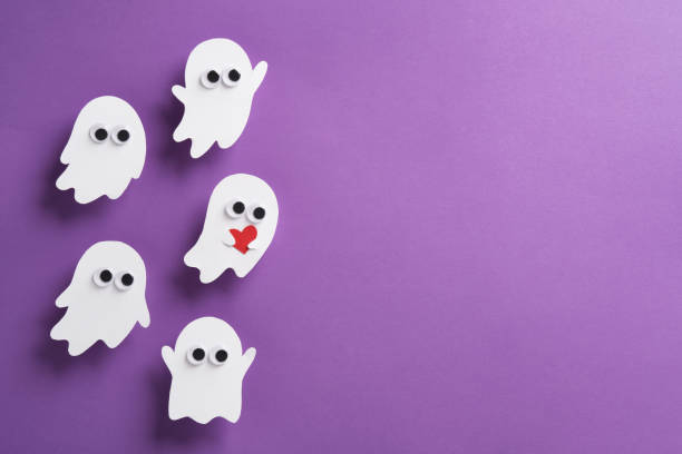istock Cute ghosts with eyes on purple background, one ghost holding a red heart, Halloween horizontal banner, place for your text 2180026754
