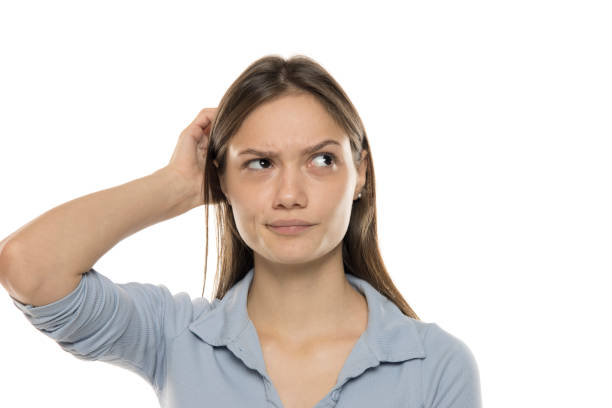 istock unsure young woman scratching her head. 2180031463