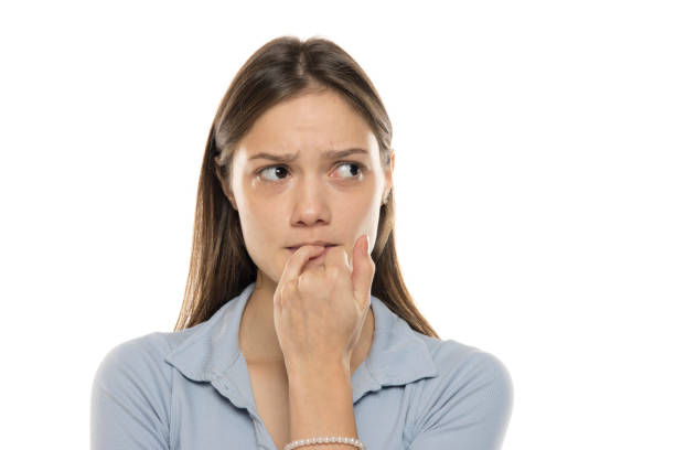 Unsure young woman biting her fingernails