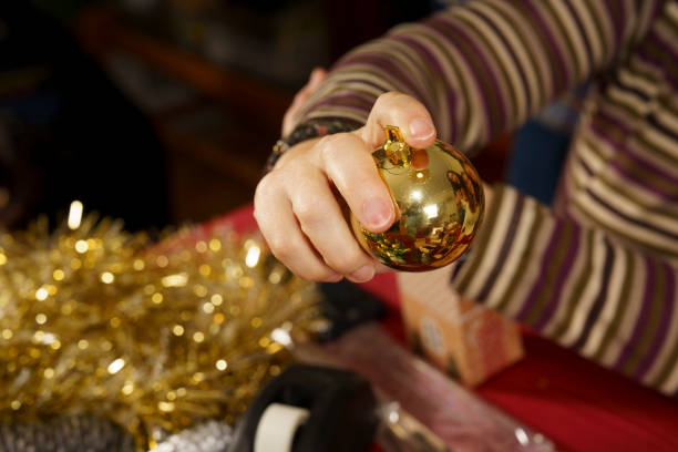 istock A person is holding a gold ornament and shaking it 2180033578