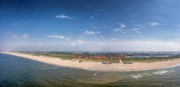 istock A panoramic view showcases a lengthy beach bordered by the ocean on one side and a town on the other 2180035816