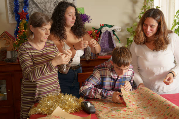 istock Family Engaged in Holiday Gift Wrapping 2180036521