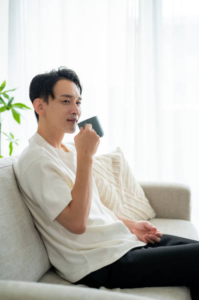 A man sitting on the sofa and holding a mug