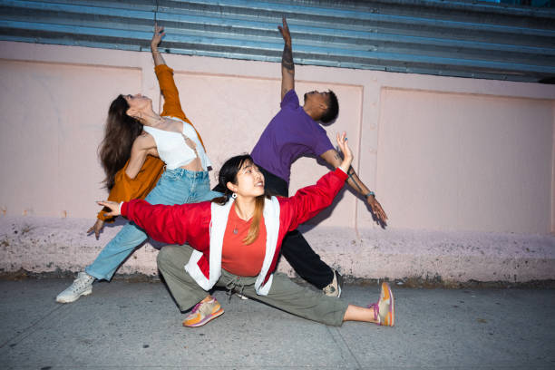 Group of three young performers dancing outdoors in the city streets in New York.