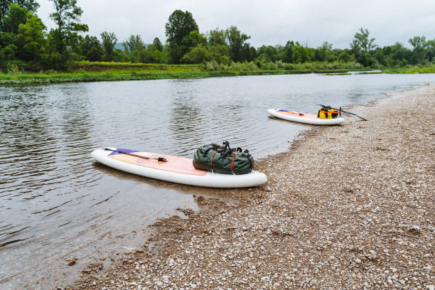 istock Immerse yourself in a serene river journey with paddleboards and camping gear amidst lush greenery. Perfect for nature enthusiasts seeking tranquility and outdoor exploration 2180044496