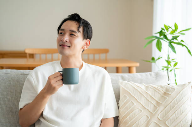 istock A man sitting on the sofa and holding a mug 2180044669