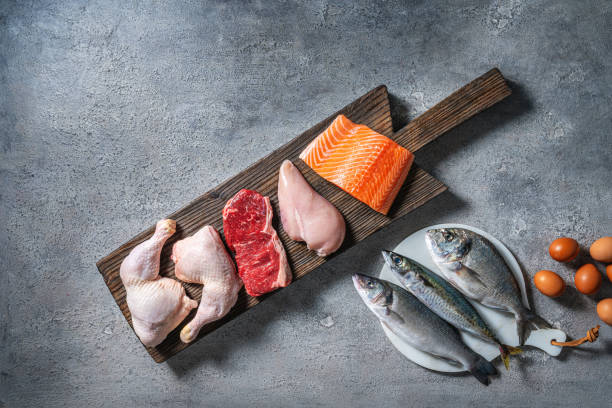 istock Healthy protein sources on a cutting board featuring chicken, beef, salmon, seabass, mackerel, and sea bream 2180045086