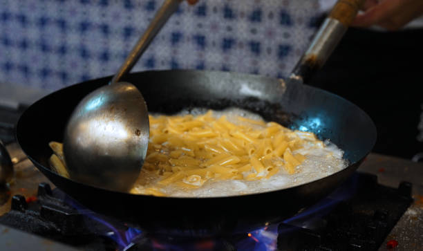 istock The pasta is cooked in a wok pan over the fire. 2180045660