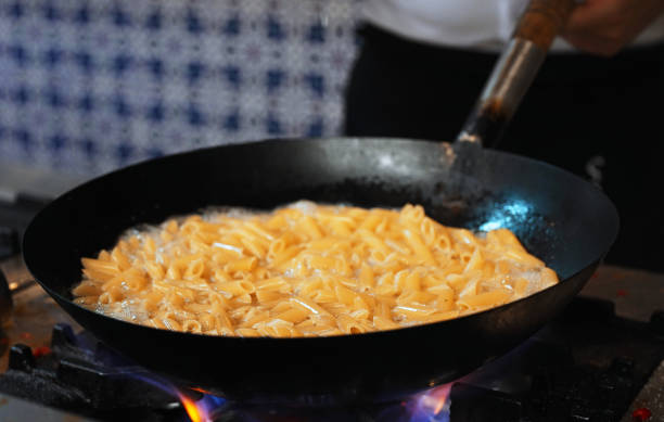 istock The pasta is cooked in a wok pan over the fire. 2180045690