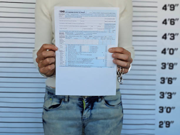 istock 1040 Income Tax Returns and Handcuffs 2180046995