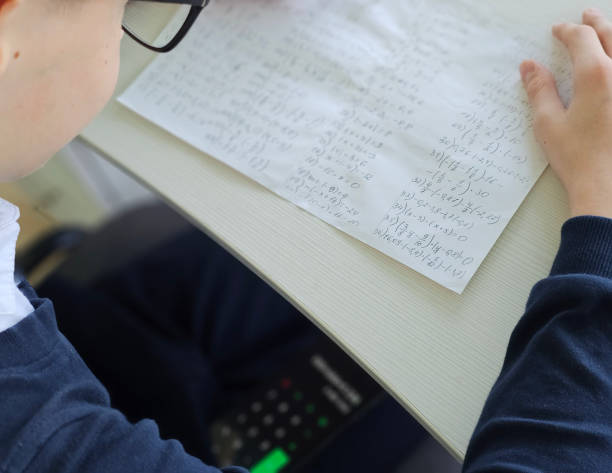 istock Student holding smartphone screen while taking math exam in school, concept of cheating in exam concept 2180048171