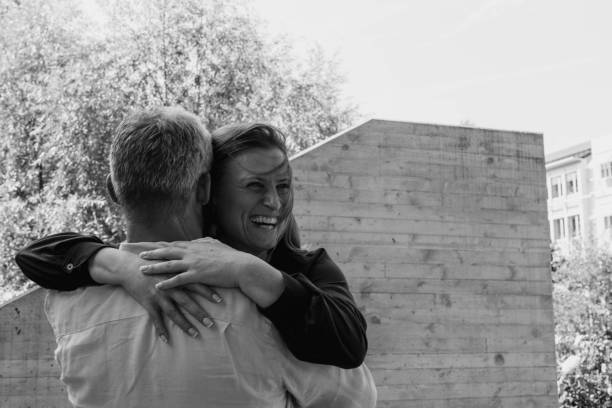istock A man and a woman standing hand in hand, looking at the camera. 2180048421