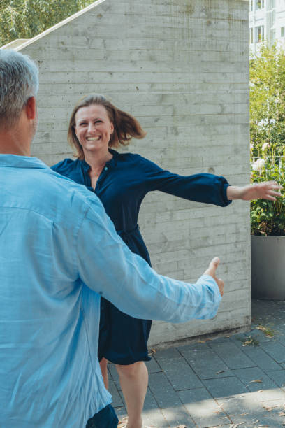 istock A man and a woman standing hand in hand, looking at the camera. 2180050910
