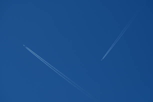 Airplane trails in the clear blue sky. Blue sky background. Contrails.