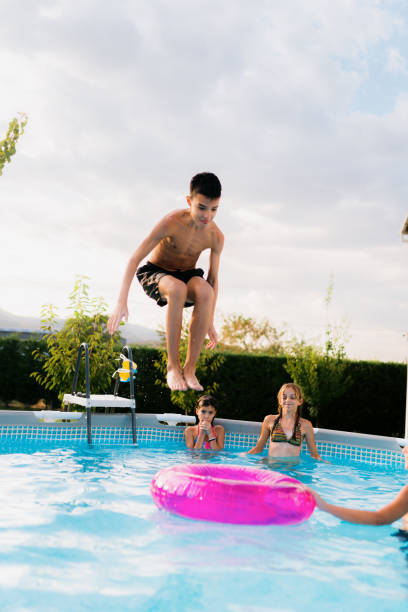 istock Teenagers having fun jumping in the swimming pool 2180051044