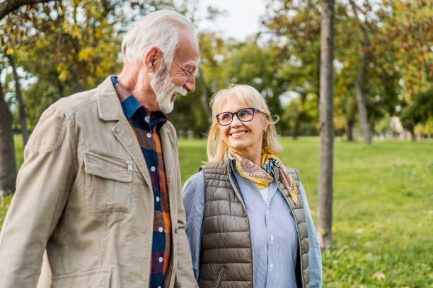 istock Happy senior couple walking in the park 2180054634