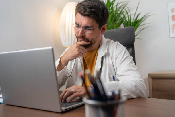 Mixed race doctor working on laptop