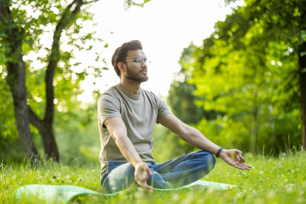 istock Young man practicing yoga meditation outdoors in serene natural setting surrounded by lush greenery and fresh air 2180057805