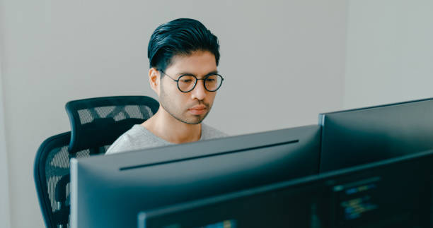 istock Young adult Asia male freelance eyeglasses typing write prompt AI bot IT app smart program nomad, video game, terminal with coding, user interface, designer, big data center on computer. 2180062052