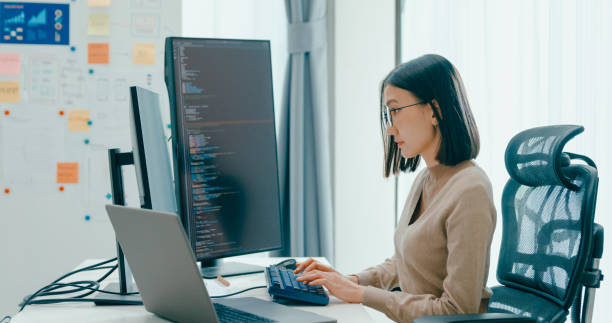 istock Young adult Asia female freelance eyeglasses typing write prompt AI bot IT app smart program nomad, video game, terminal with coding, user interface, designer, big data center on computer. 2180062090