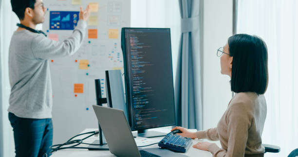 istock Group Asia male female software developers mentor leader manager talk strategy plan to executive write prompt AI bot IT app program nomad, video game, data center. Whiteboard slideshow code. 2180062103