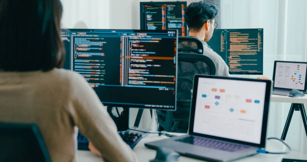 istock Group Asia male, female freelance typing write prompt AI bot IT app smart program nomad, video game, terminal with coding language, user interface, designer, big data center on desktop computer. 2180062118