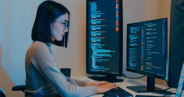istock Young Asia female freelance eyeglasses typing write prompt AI bot IT app smart program nomad, video game, terminal with coding language, designer, big data center on computer in night office. 2180062144