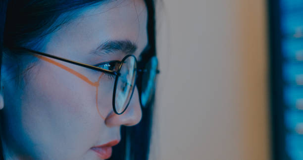 istock Closeup Asia female freelance eyeglasses typing write prompt AI bot IT program nomad, video game, terminal with coding language, designer, big data center on desktop computer in night office. 2180062168