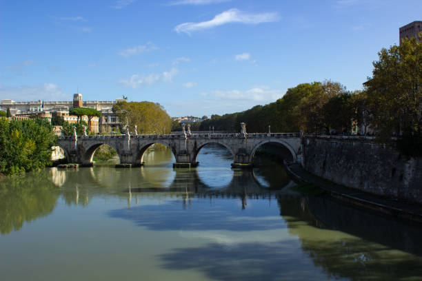 Rome, Italy, December 26 -- The sunset light warms the Tiber river in Rome along the imposing travertine embankments built at the beginning of the twentieth century, with a view of the famous Ponte Sisto and a view of Trastevere. Image in HD format