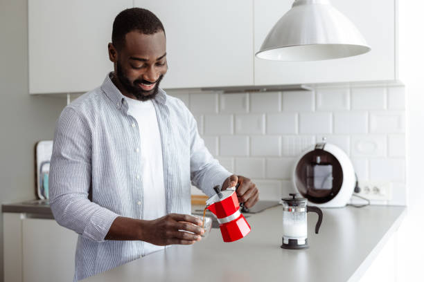 istock Smiling man making espresso in a kitchen at home 2180063546