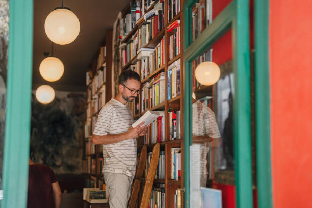 Photo of a mid adult man who is an employee in a local bookstore