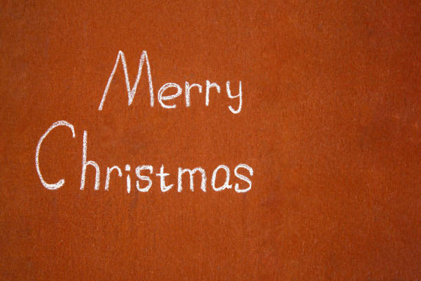 Merry Christmas written by hand with chalk, on an abstract background