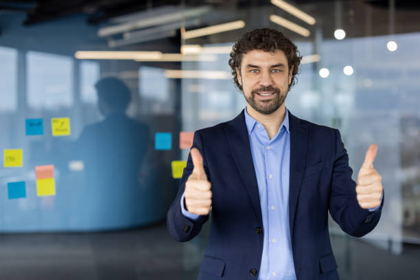 istock Confident business professional giving thumbs up in modern office environment showcasing success and positivity 2180069953