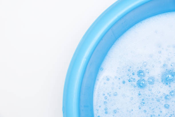 istock Blue basin with water and white foam bubbles foam water soap suds texture foam close up, copy space 2180070373