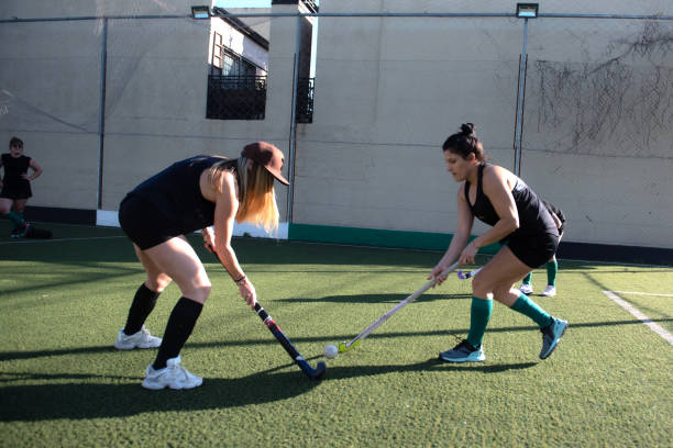 Women playing a hockey match