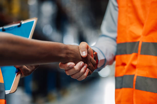 istock Two business partners shaking hands in warehouse 2180076679