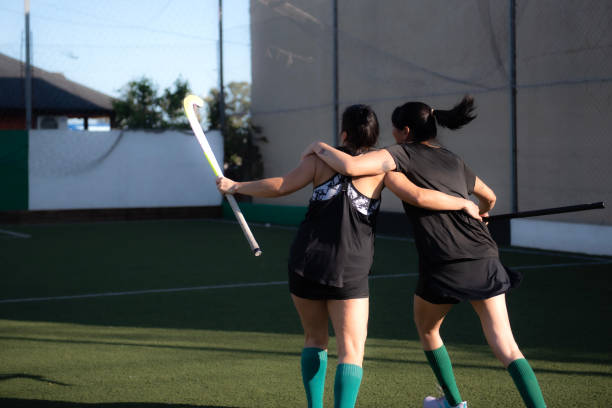 Field hockey players celebrating a goal enthusiastically