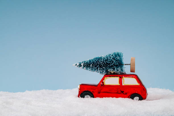 istock Winter composition made with red car with Christmas tree and snow on blue background. Minimal Christmas and New Year concept. Creative festive holiday layout. Xmas aesthetic. 2180083412