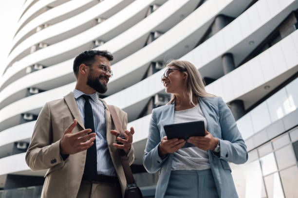 istock Businesspeople discussing while walking outside office building 2180092708