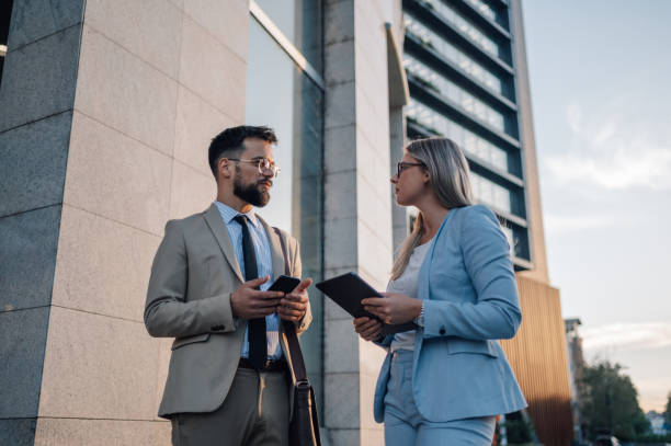 istock Businesspeople having conversation about work outside office building 2180092754
