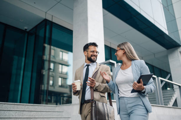 istock Business people walking and talking outside office building 2180092770