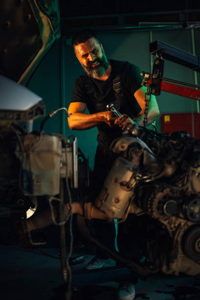 istock Mechanic repairing car engine using wrench in a dim garage. 2180093067